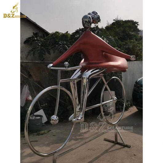 An abstract metal sculpture of a woman wearing a ponytail and riding a bicycle DZM 1364 (2)