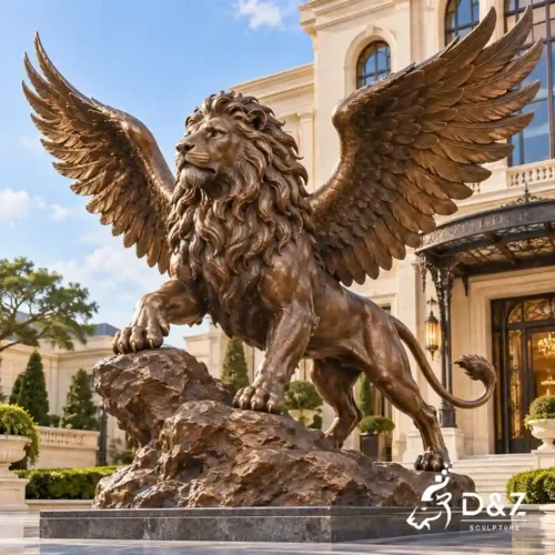 Large bronze flying lion statue with outstretched feathered wings, a flowing mane, and one paw raised on a rocky base at a luxury hotel entrance.