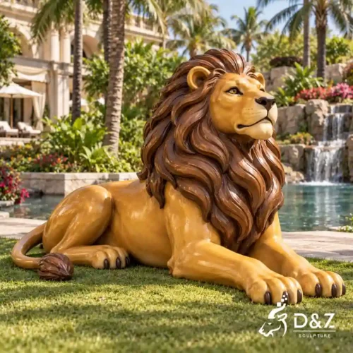 Large bronze painted lion statue reclining on a resort lawn with a golden-yellow body and reddish-brown mane Large bronze painted lion statue reclining on a resort lawn with a golden-yellow body and reddish-brown mane
