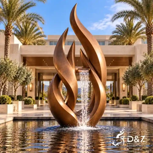 Large bronze flame water fountain with curved abstract forms and cascading water at a luxury hotel entrance.