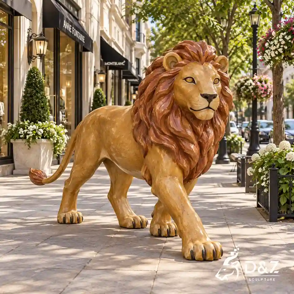 Large walking bronze lion sculpture with a golden body and reddish-brown mane on a landscaped shopping street Large walking bronze lion sculpture with a golden body and reddish-brown mane on a landscaped shopping street