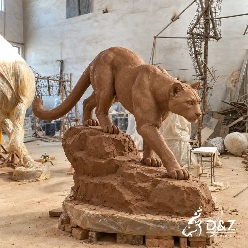 Concept visualization of a clay mountain lion bronze sculpture model in a sculpting workshop with a rock base. Concept visualization of a clay mountain lion bronze sculpture model in a sculpting workshop with a rock base.